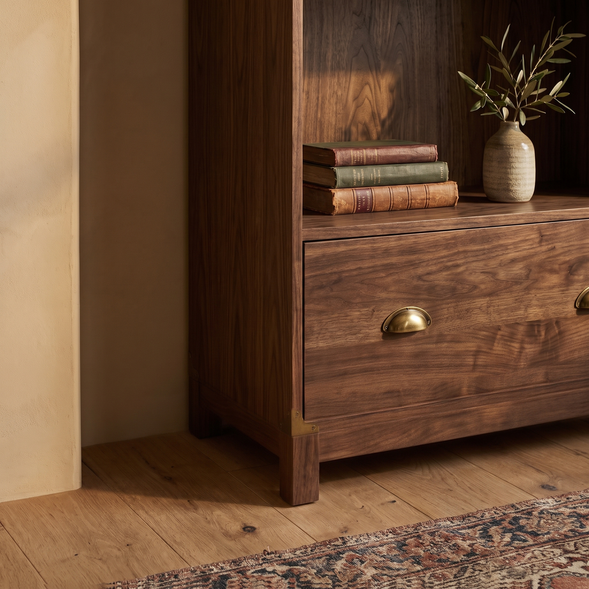 Walnut bookcase detail with leather bound books and brass pull