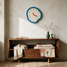 Ondara clock in blue above a walnut console